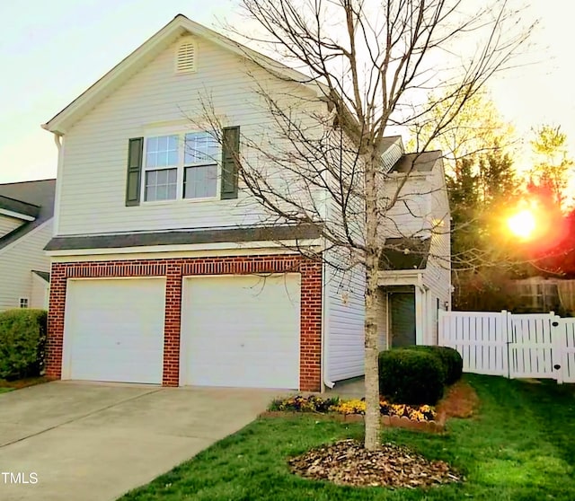 traditional-style home featuring a garage, concrete driveway, brick siding, and fence