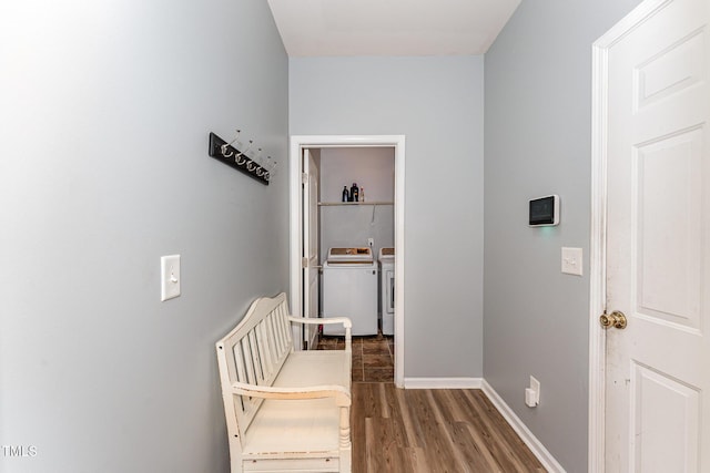 hallway with washer and clothes dryer, baseboards, and wood finished floors