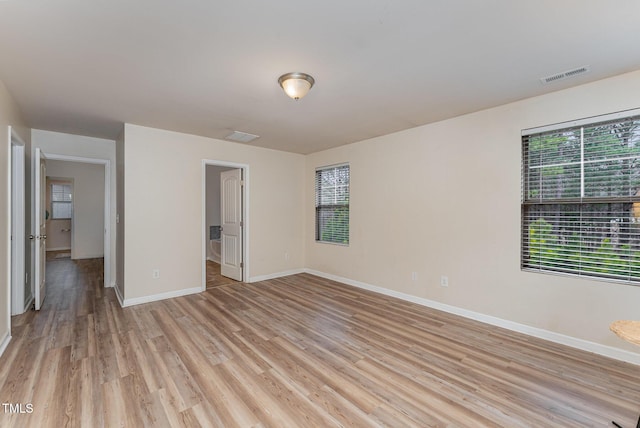 unfurnished bedroom with light wood finished floors, visible vents, and baseboards