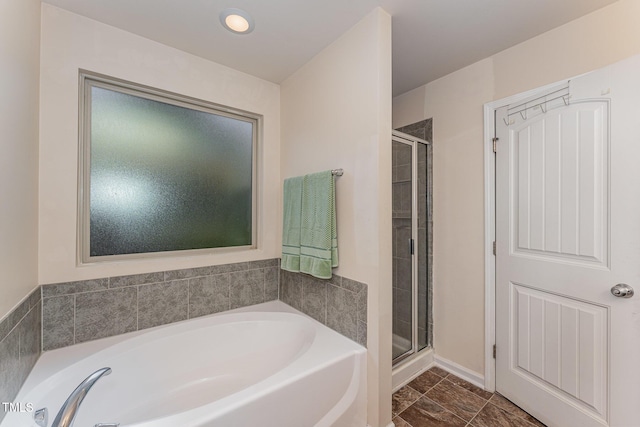 bathroom featuring a stall shower and a garden tub