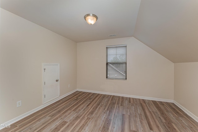 bonus room featuring vaulted ceiling, wood finished floors, visible vents, and baseboards