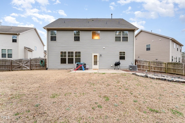 back of property with a lawn, a patio, a fenced backyard, a gate, and central AC