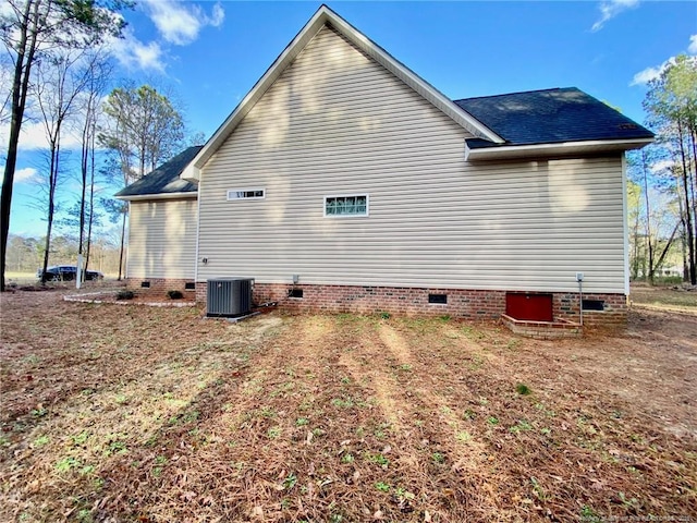 view of side of home featuring central AC and crawl space