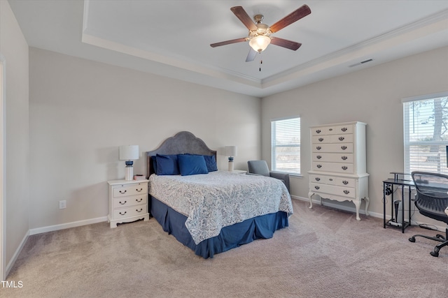 bedroom with light carpet, multiple windows, a raised ceiling, and baseboards