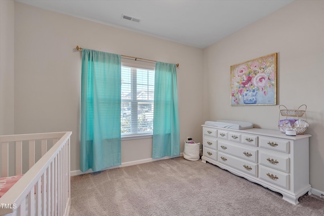 carpeted bedroom featuring a crib, baseboards, and visible vents