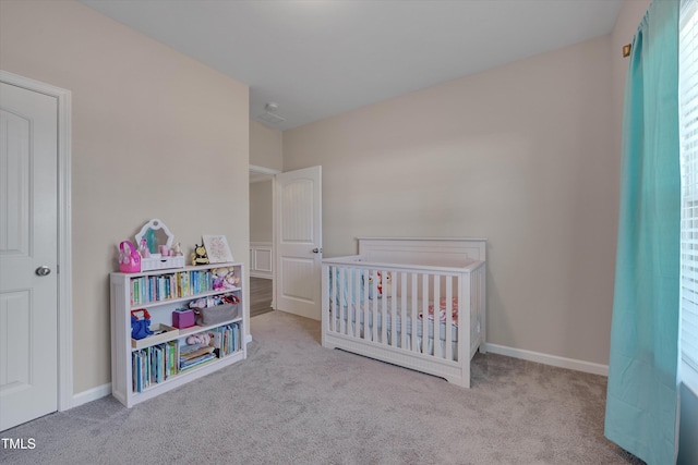 bedroom featuring a nursery area, carpet flooring, and baseboards