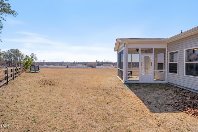 view of yard featuring a sunroom and fence