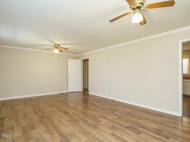 spare room featuring baseboards, ornamental molding, and wood finished floors