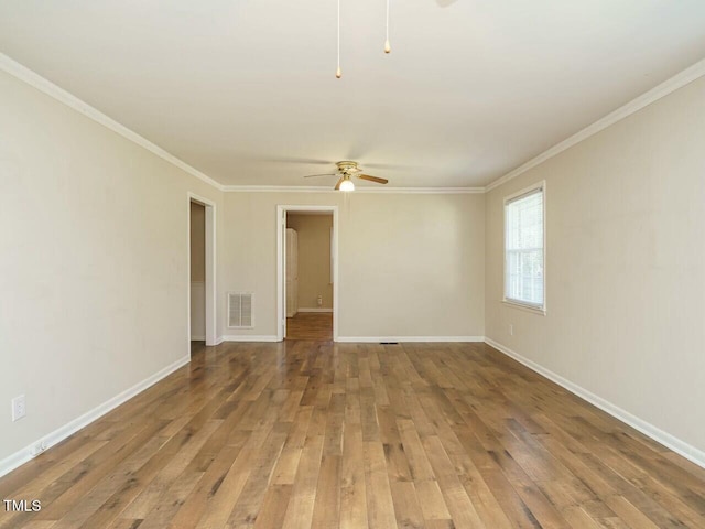 unfurnished room with hardwood / wood-style flooring, visible vents, baseboards, and ceiling fan