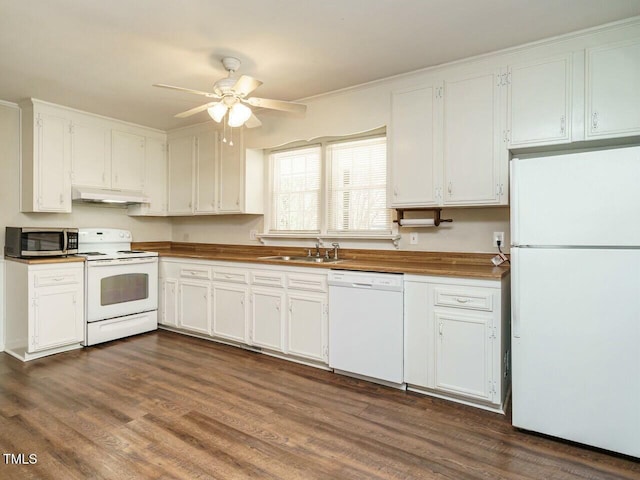 kitchen with under cabinet range hood, white appliances, a sink, white cabinetry, and dark wood-style floors