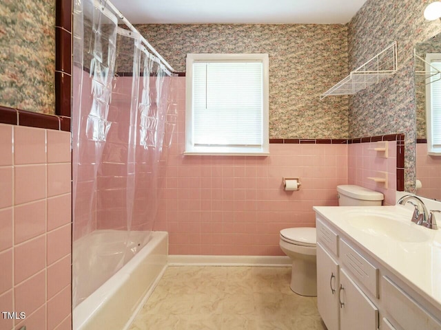 full bath featuring wallpapered walls, toilet, a wainscoted wall, shower / tub combo with curtain, and vanity