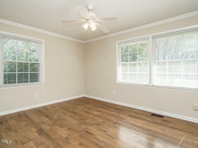 spare room featuring visible vents, crown molding, baseboards, and hardwood / wood-style flooring