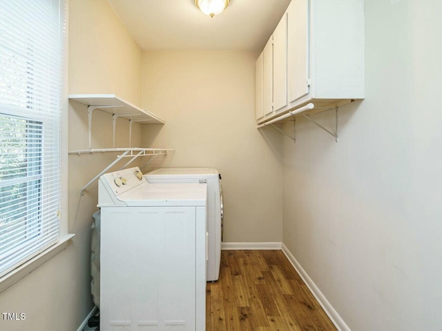 laundry area featuring a healthy amount of sunlight, cabinet space, independent washer and dryer, and baseboards