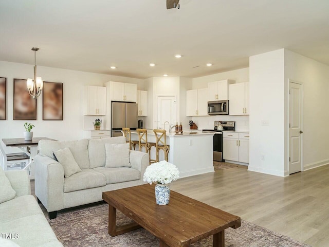 living room featuring light wood-style floors, recessed lighting, and baseboards