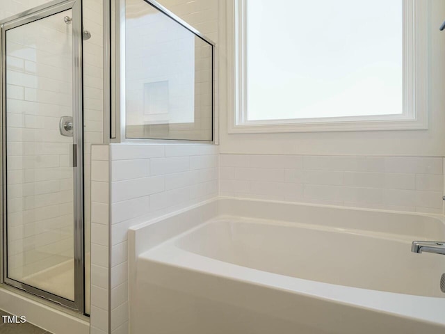 bathroom with a garden tub and a shower stall