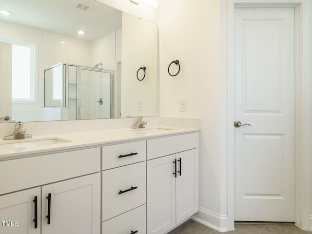 full bathroom featuring visible vents, a sink, a shower stall, and double vanity