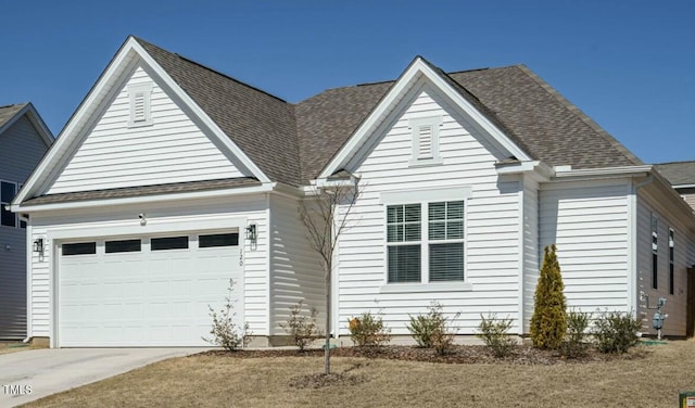 view of front of property featuring a garage, driveway, and a shingled roof