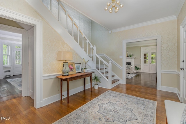 entrance foyer featuring ornamental molding, radiator, stairway, and wallpapered walls