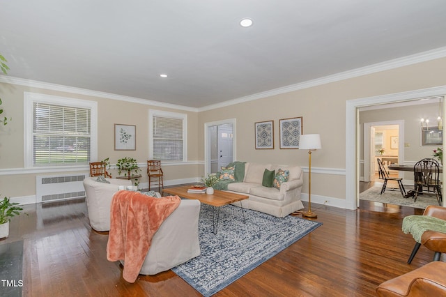 living room with baseboards, radiator heating unit, wood finished floors, and crown molding