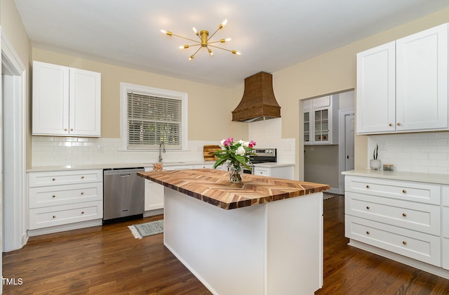 kitchen featuring butcher block counters, custom exhaust hood, stainless steel appliances, and dark wood-style flooring