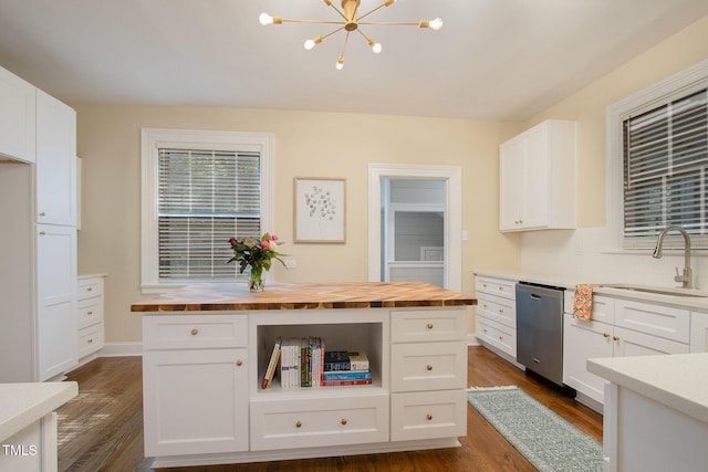 kitchen featuring dishwasher, dark wood-style floors, butcher block counters, white cabinetry, and a sink