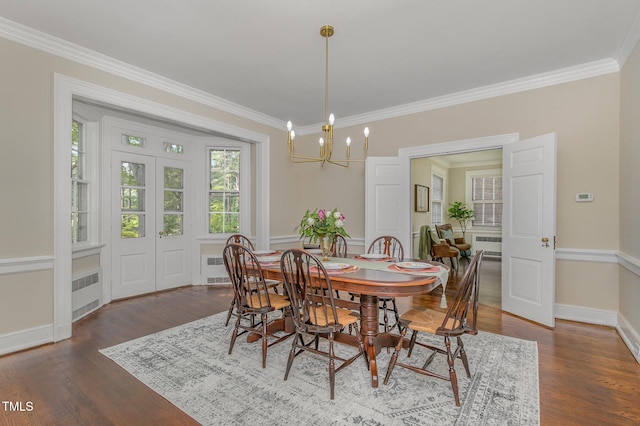 dining room featuring dark wood-style floors, ornamental molding, radiator heating unit, and a notable chandelier