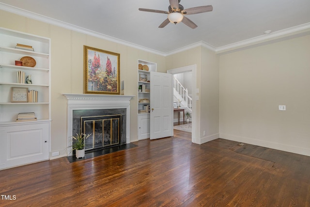 unfurnished living room with built in shelves, wood finished floors, a fireplace with flush hearth, a ceiling fan, and ornamental molding