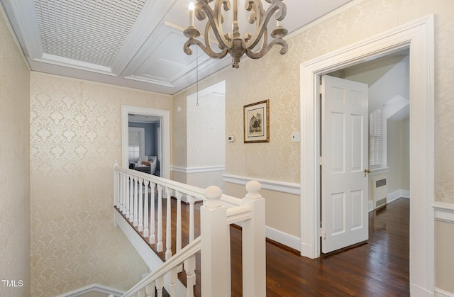 corridor with dark wood finished floors, visible vents, an upstairs landing, baseboards, and wallpapered walls