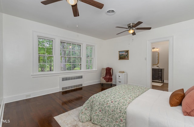 bedroom with ceiling fan, wood finished floors, visible vents, baseboards, and radiator