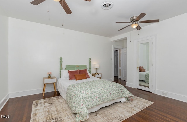 bedroom with wood finished floors, visible vents, and baseboards