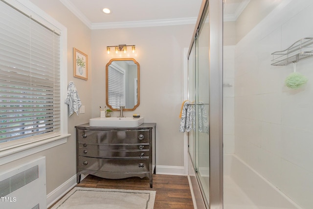 full bathroom featuring radiator, a shower with door, baseboards, and crown molding