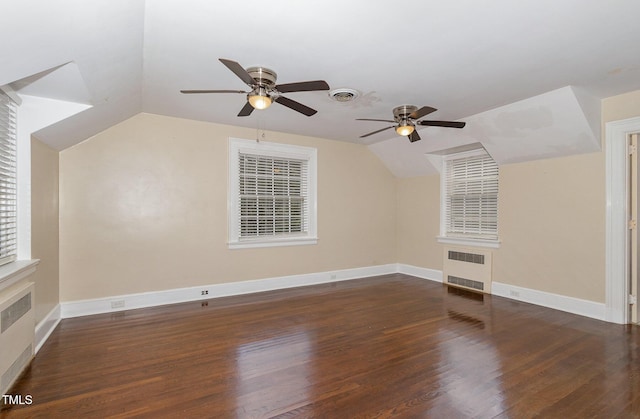 bonus room featuring lofted ceiling, visible vents, radiator heating unit, wood finished floors, and baseboards