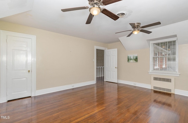 spare room with baseboards, visible vents, radiator heating unit, and wood finished floors