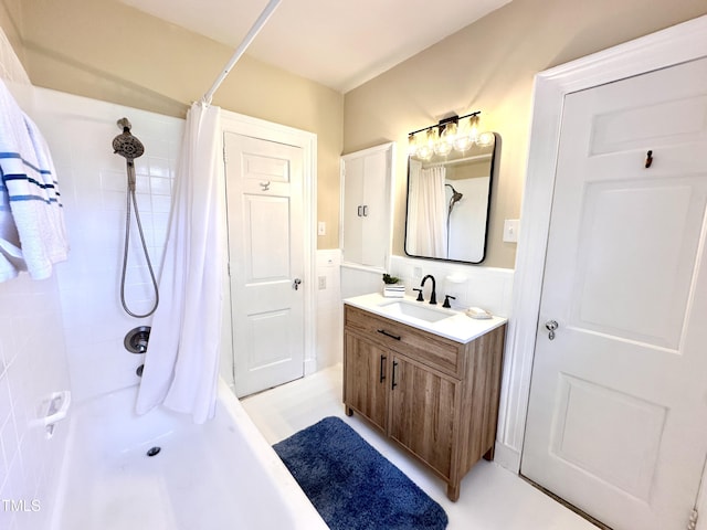 bathroom with wainscoting, tile walls, a shower with shower curtain, and vanity