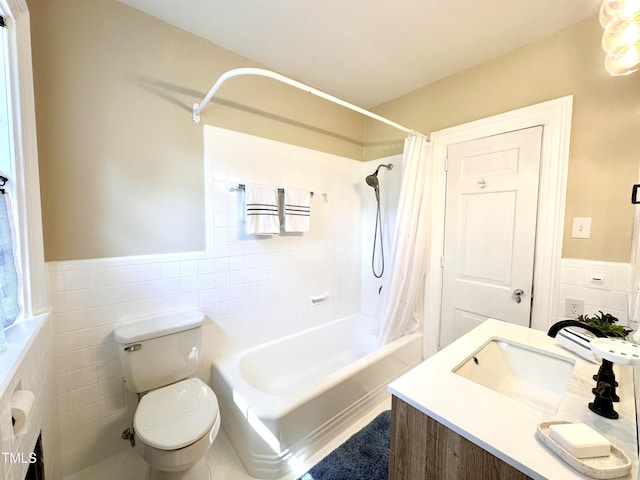 bathroom with shower / bath combination with curtain, a wainscoted wall, tile walls, and toilet