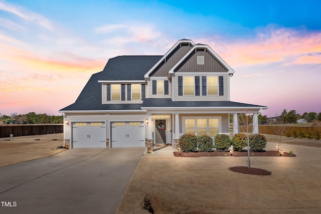 view of front of property with covered porch, a shingled roof, fence, concrete driveway, and board and batten siding