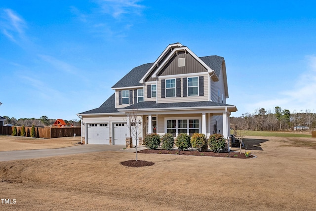 view of front of property with driveway, roof with shingles, fence, board and batten siding, and a front yard