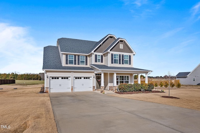 craftsman inspired home featuring roof with shingles, concrete driveway, covered porch, board and batten siding, and a garage