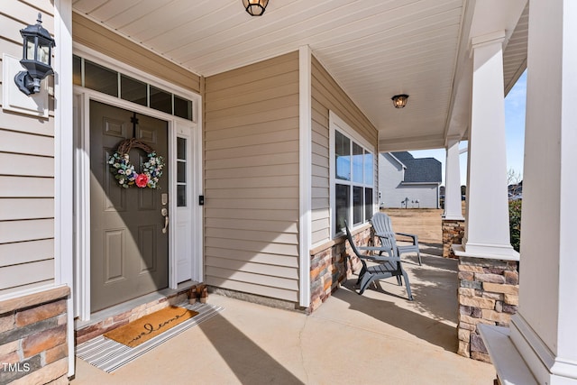 property entrance featuring covered porch and stone siding