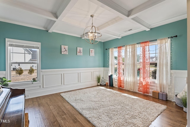 interior space with visible vents, coffered ceiling, wood-type flooring, beamed ceiling, and a chandelier