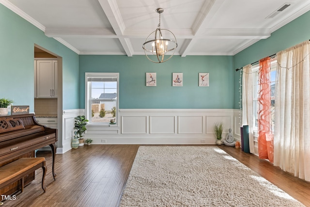 interior space with coffered ceiling, wood finished floors, visible vents, beamed ceiling, and an inviting chandelier