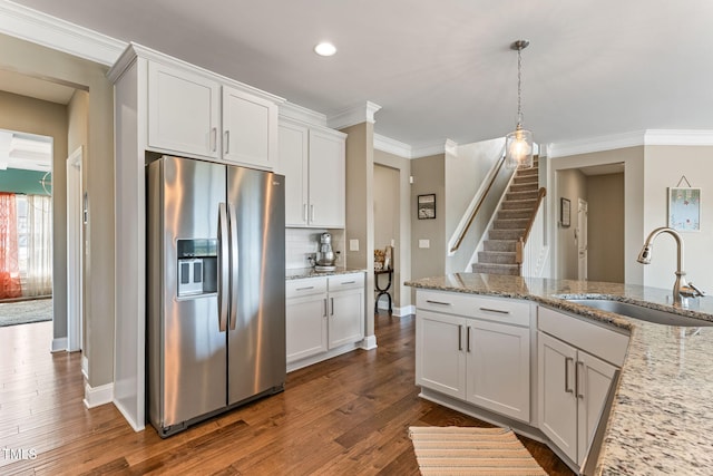 kitchen featuring dark wood-style flooring, ornamental molding, a sink, light stone countertops, and stainless steel fridge with ice dispenser