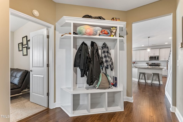 mudroom featuring dark wood-type flooring, recessed lighting, and baseboards