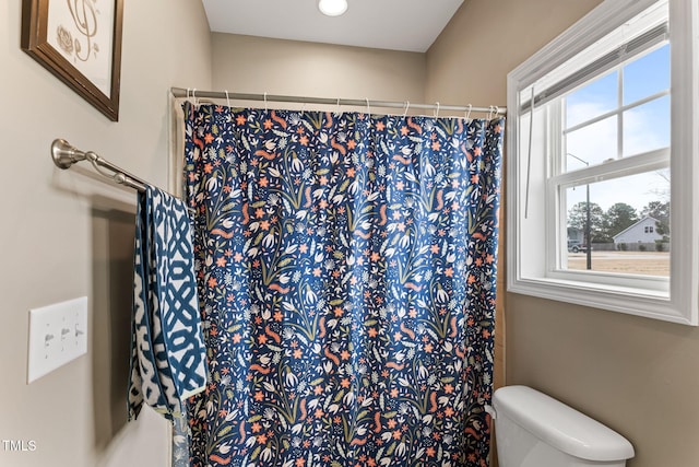 bathroom featuring curtained shower and toilet