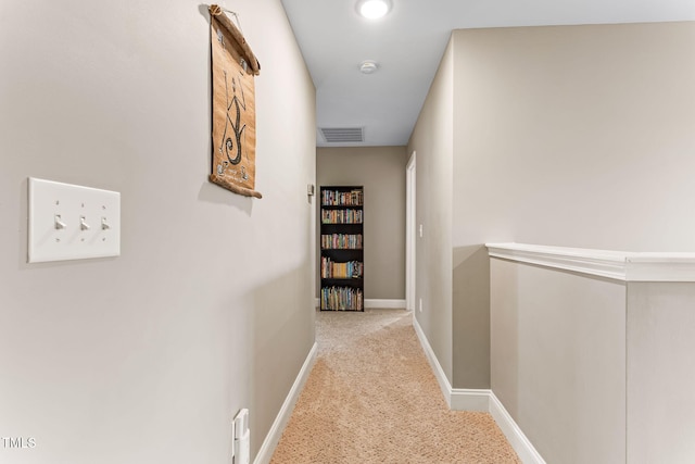 corridor featuring carpet flooring, visible vents, and baseboards