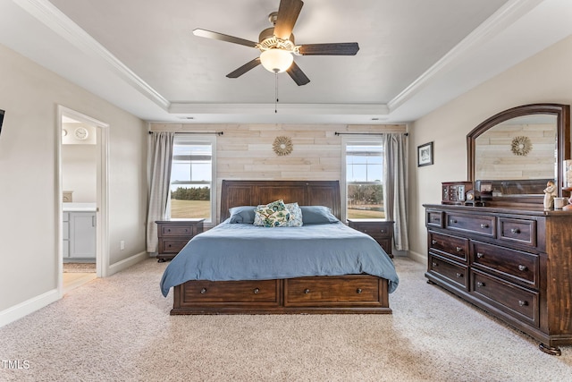 bedroom with light carpet, multiple windows, a raised ceiling, and baseboards