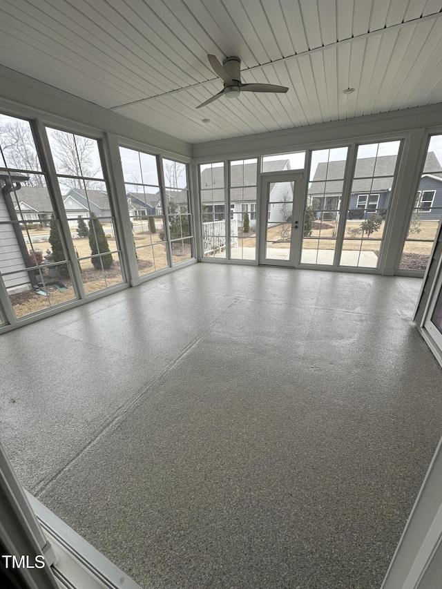 unfurnished sunroom with a residential view, wood ceiling, and ceiling fan