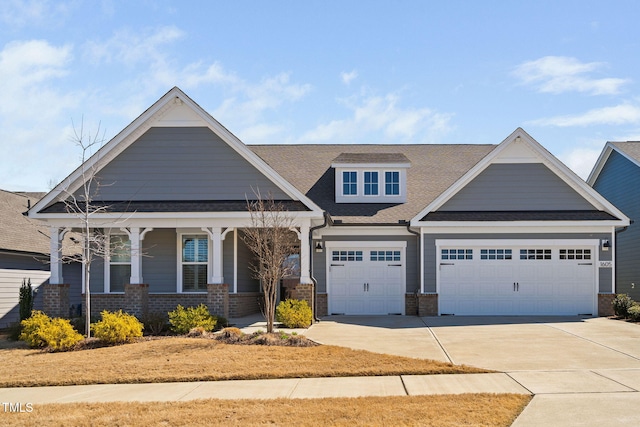 craftsman inspired home featuring brick siding, covered porch, concrete driveway, and an attached garage