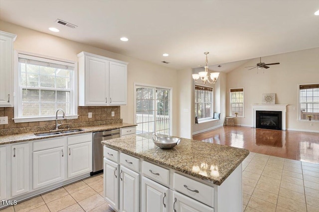 kitchen with visible vents, decorative backsplash, dishwasher, ceiling fan with notable chandelier, and a sink
