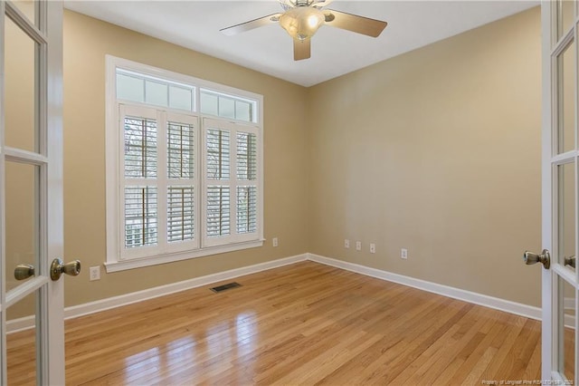 spare room with baseboards, french doors, visible vents, and light wood-style floors